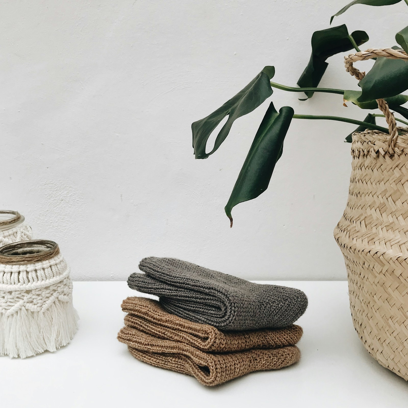 A neat stack of folded white towels beside a woven basket of more towels, the quiet ready-and-warm setup that makes a confinement sponge bath actually pleasant